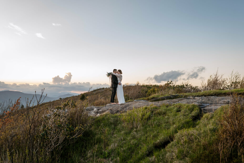 A couple stands in the distance on a mountain in NC for their elopements first dance.