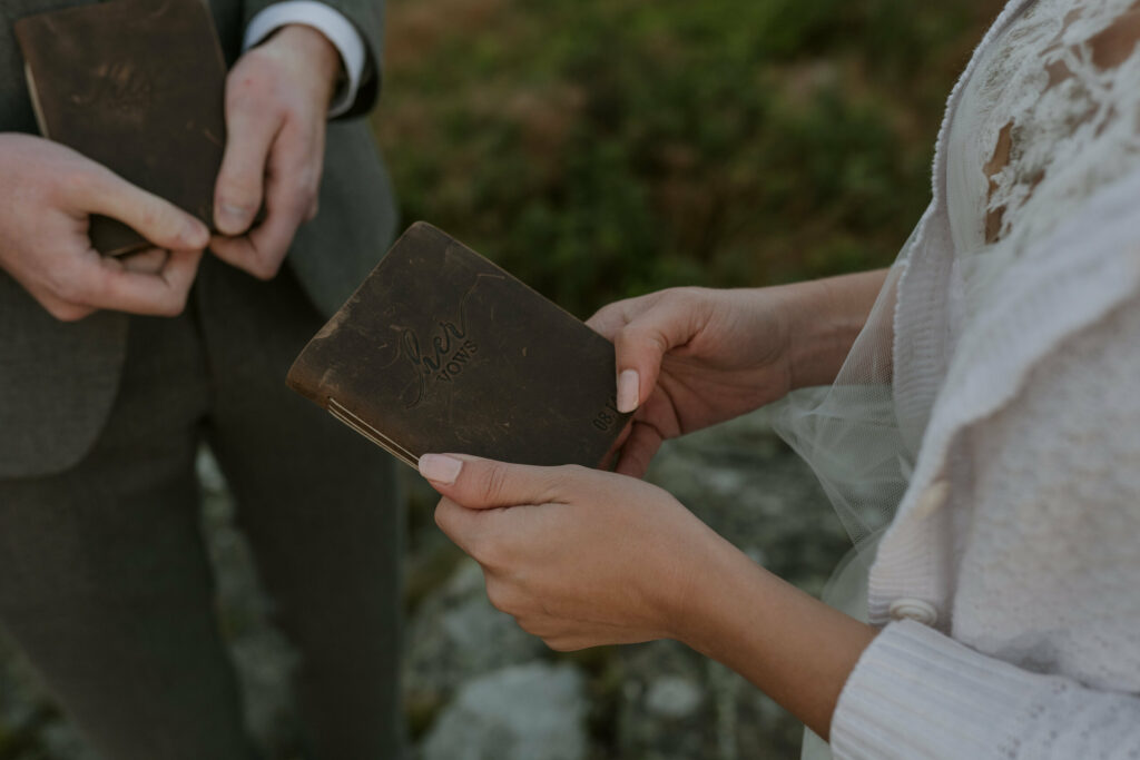 A bride holds her vow book in her hands before she reads them to her groom during their mountain elopement.