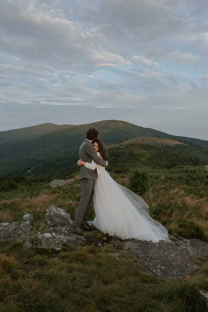 A bride and groom hug each other during their elopement vows on a mountain in the blue ridge.
