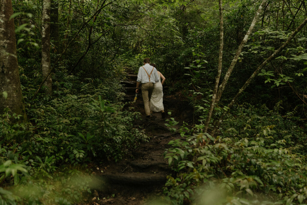 A couple is hiking through the forest in North Carolina during their elopement day.