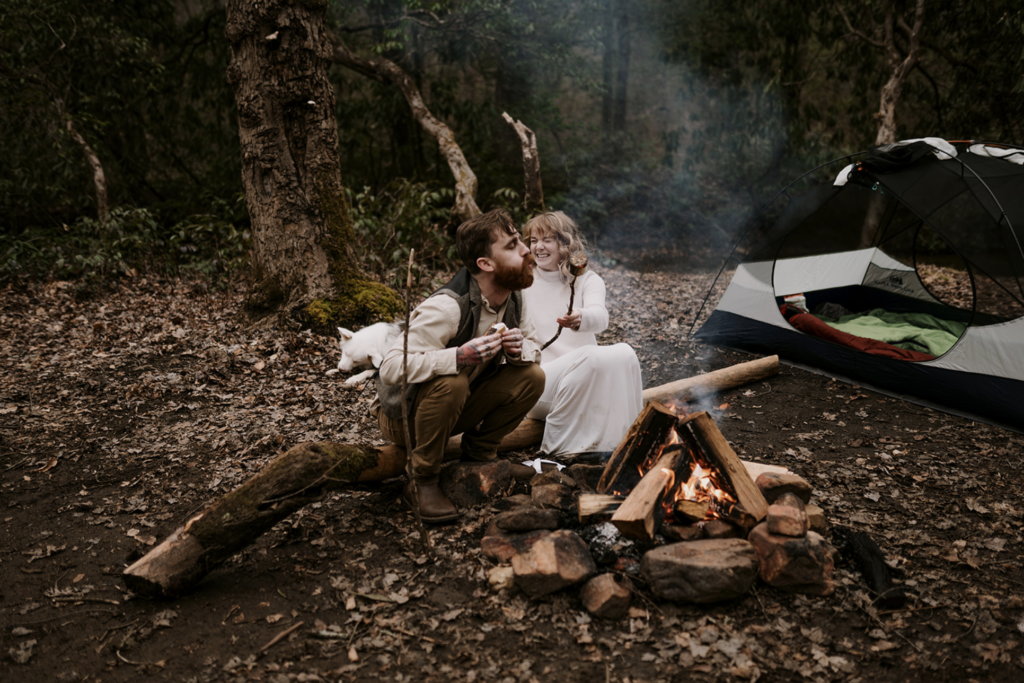 Photo of a couple with s’mores around a campfire with your pup nearby and the photographer just taking pictures of what naturally happens.
