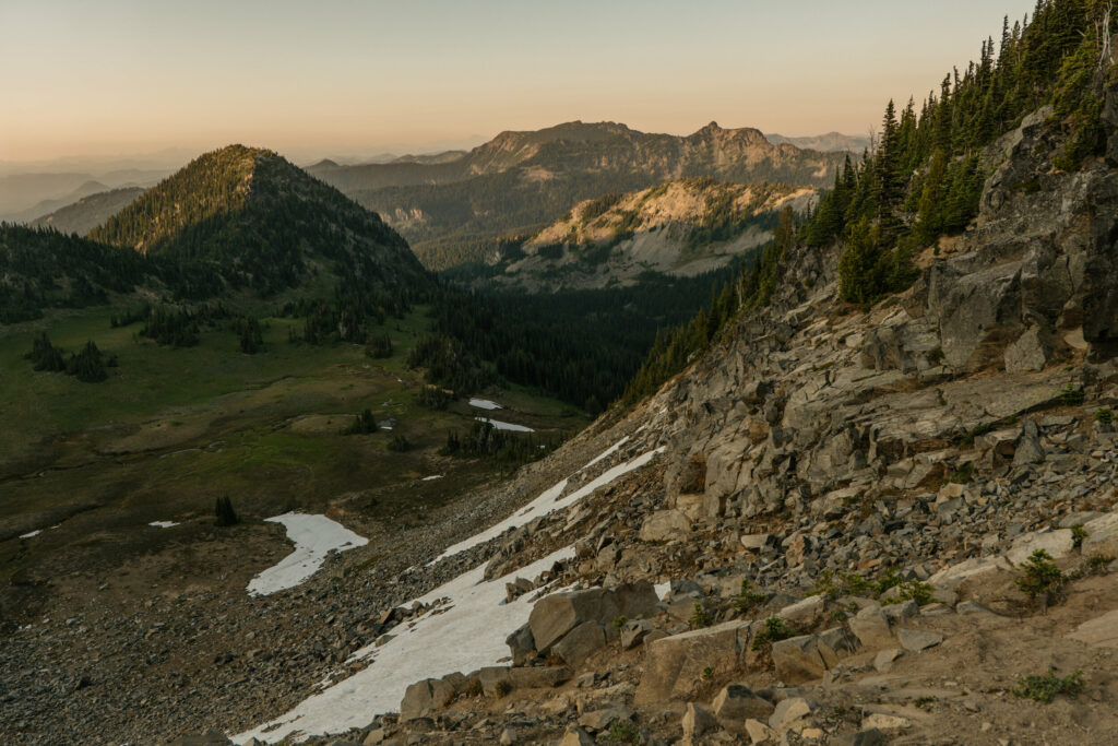 A sunset view of rocky cliffs and snow patches in Mt Rainier national park. This location is perfect for Mount Rainier Elopements.