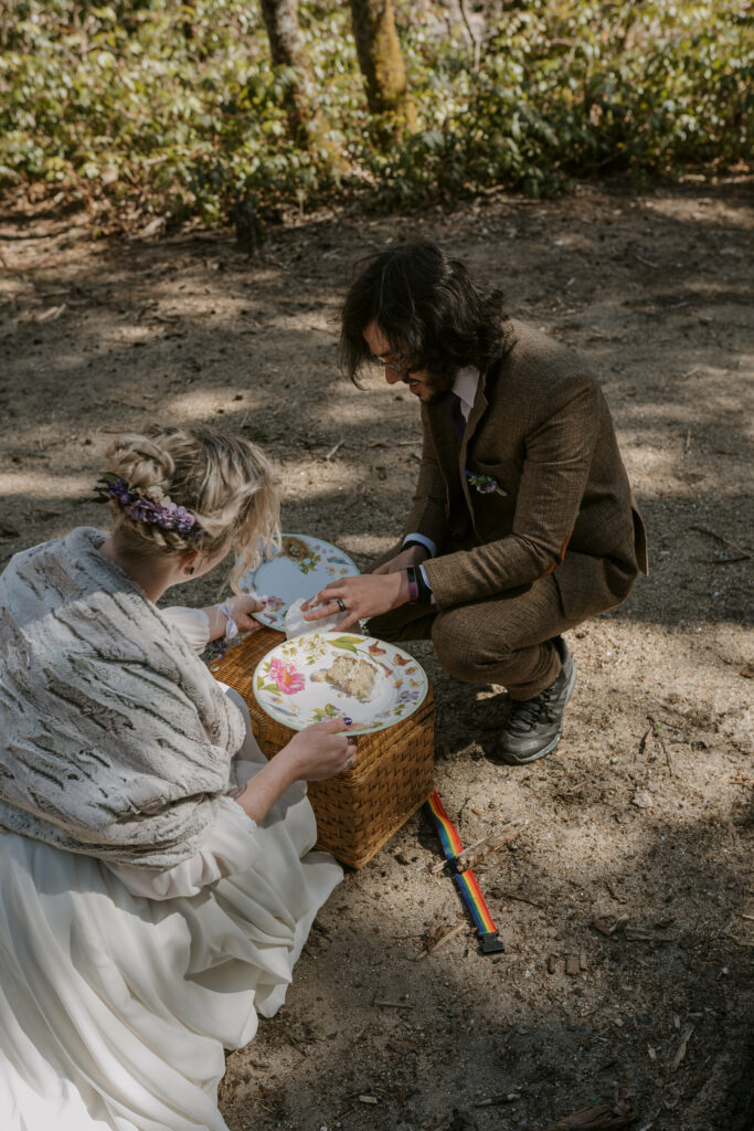 A husband and wife sort out printed plates on a sandy creek bed for a picnic.
