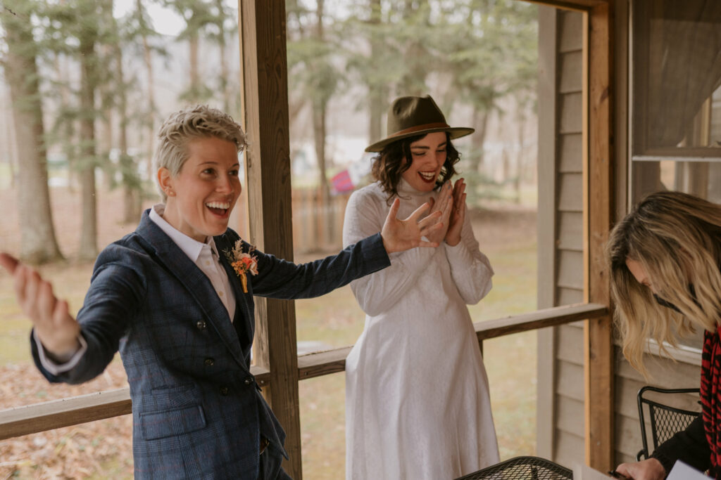A person holds their arms outstretched excitedly after their wedding license is signed.