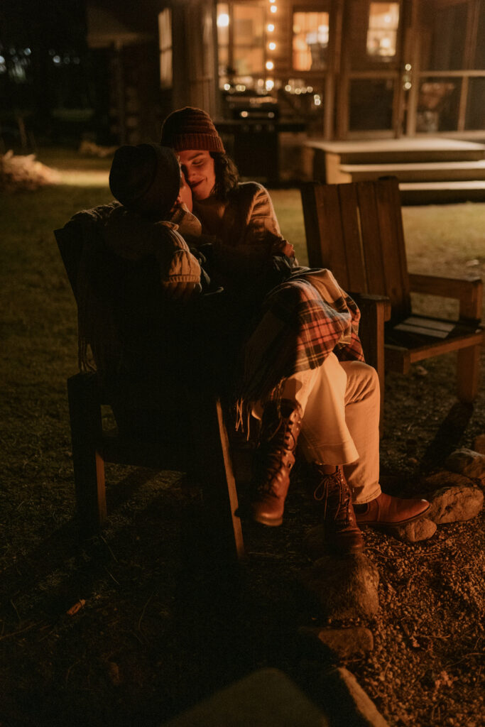 A couple snuggling by a fire in the dark on a cold night in Asheville.