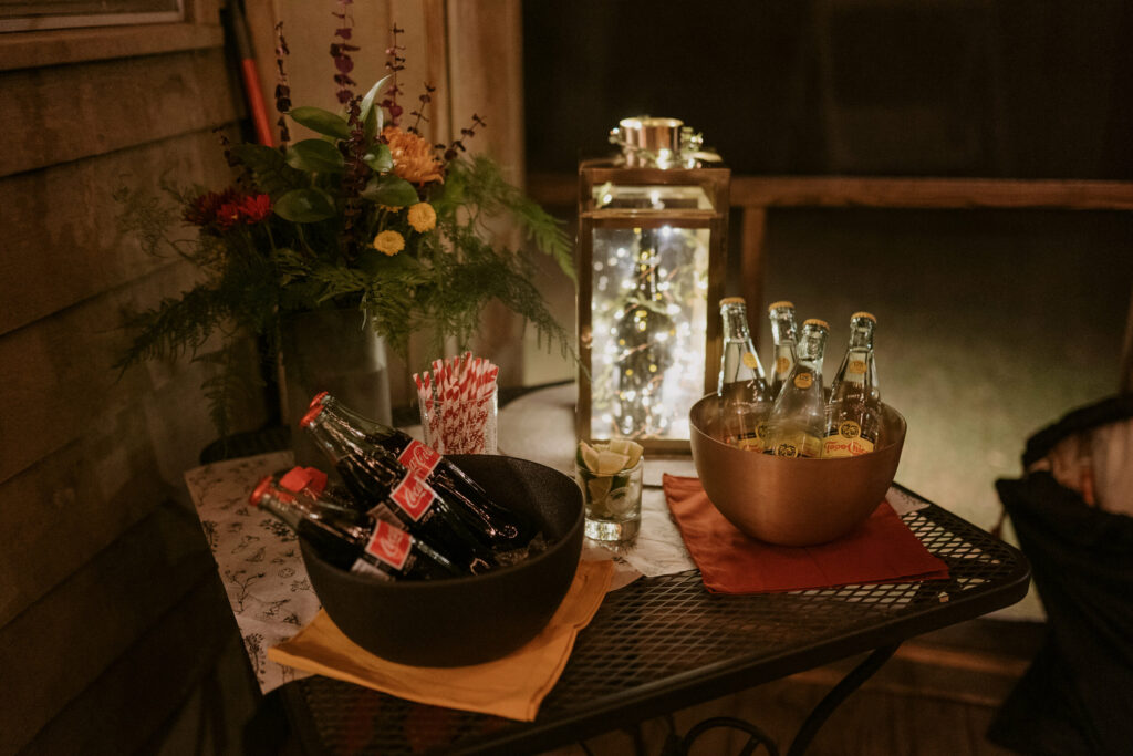 Glass bottles of coke sit in a bowl on a table.