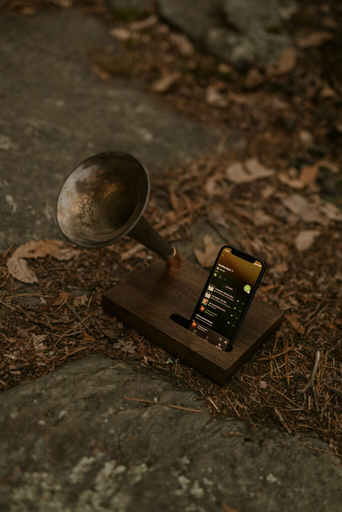 A phone connected to a vintage gramophone sits on a rock.