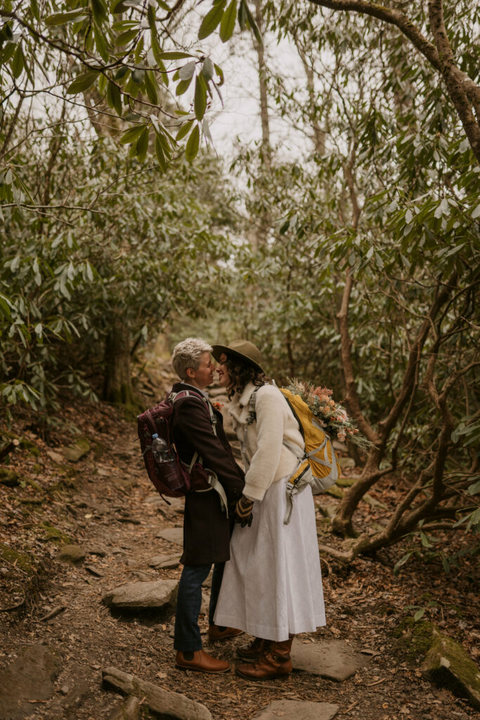 A couple kisses among rhododendrons in NC mountains.