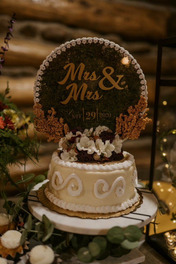A Mrs & Mrs wedding cake decorated with flowers.