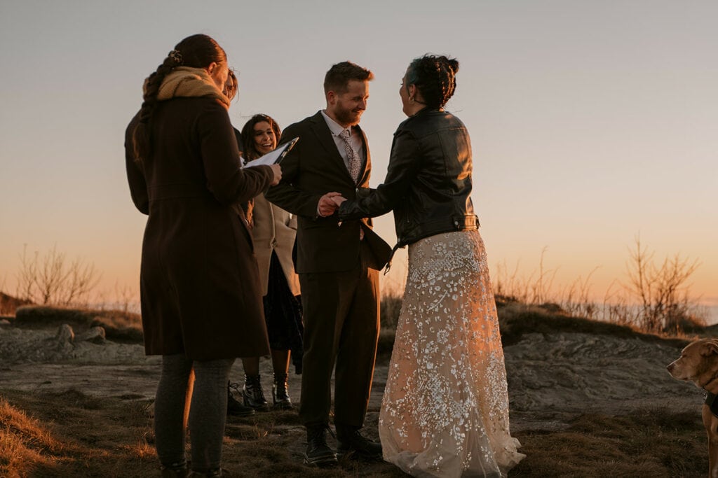 a couple is smiling and being silly during their ceremony on a mountain at Black Balsam Knob at sunrise.