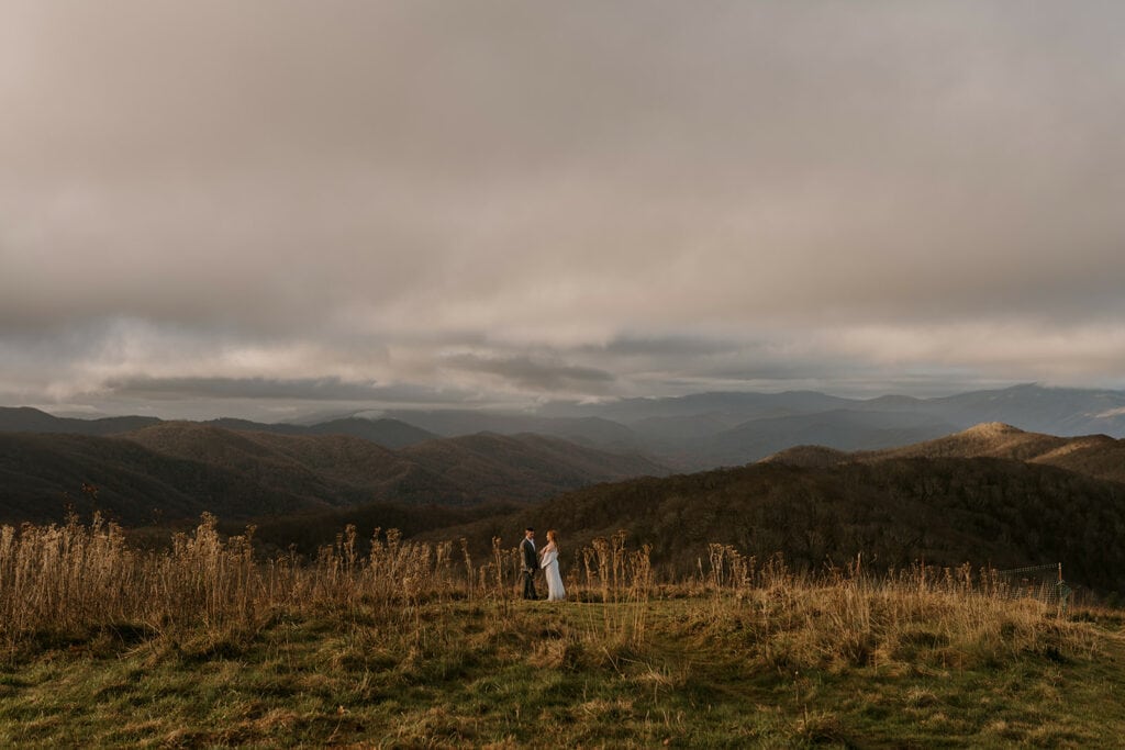 A couple stands facing each other on top of Max Patch during their elopement.