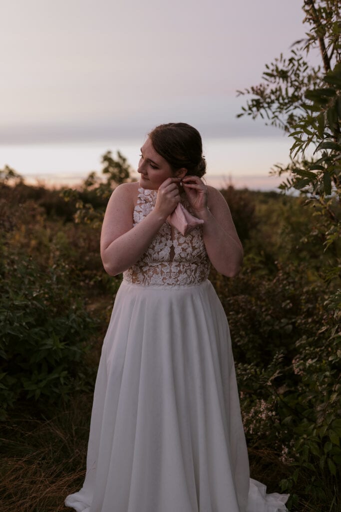 Bride putting her earrings in while she gets ready for her sunrise elopement