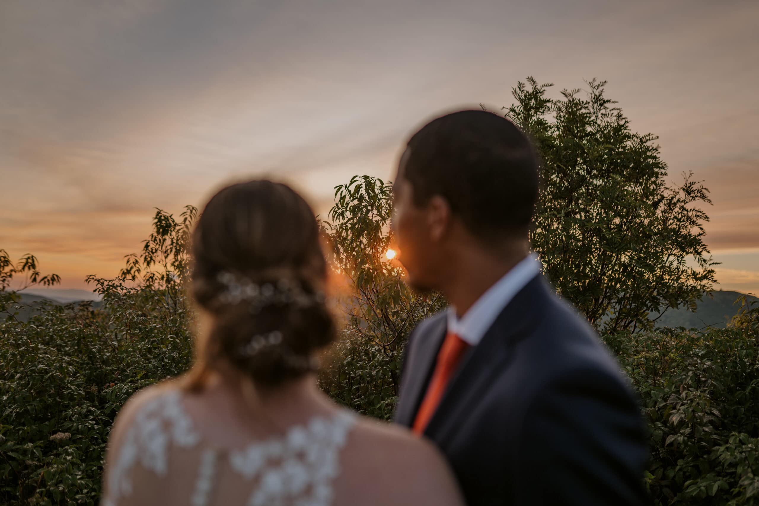 Bride and groom hugging as they watch the sunrise during their elopement