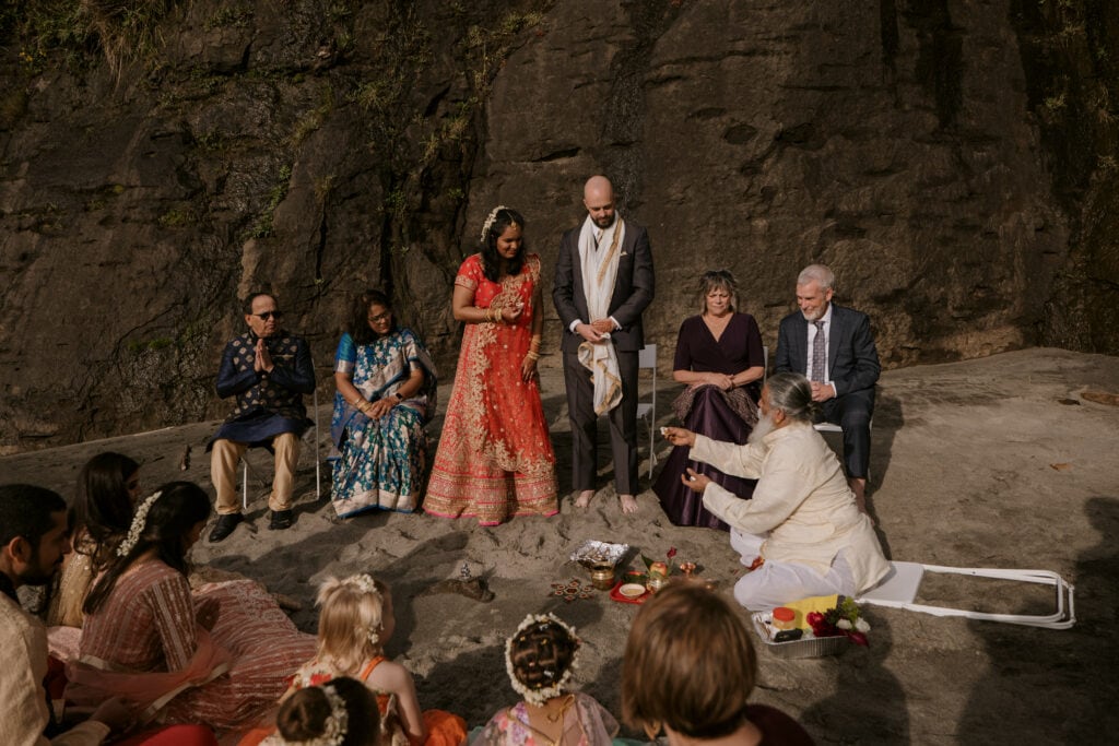 Elopement Ceremony on the Beach with Family Surrounding the Couple