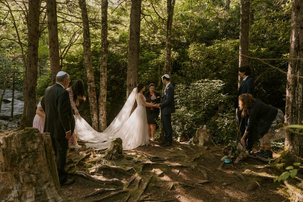A family is getting set up at the beginning of a Jewish ceremony in the forest.